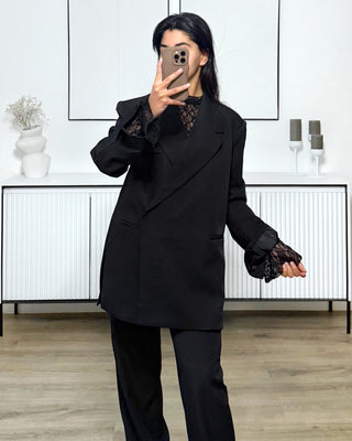 Top en dentelle noir d’une longueur de 56 cm, manches évasée et col montant.