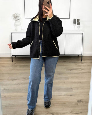 Veste zippée bicolore noir avec finitions contrastées jaunes, col montant et poches latérales, style casual chic