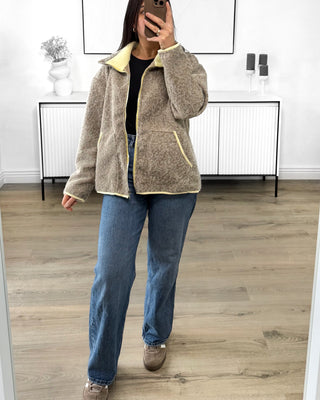 Veste zippée bicolore taupe avec finitions contrastées jaunes, col montant et poches latérales, style casual chic.